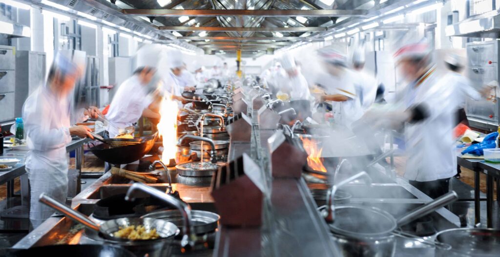chefs working in kitchen with motion blur using slow shutter speed in food photography 