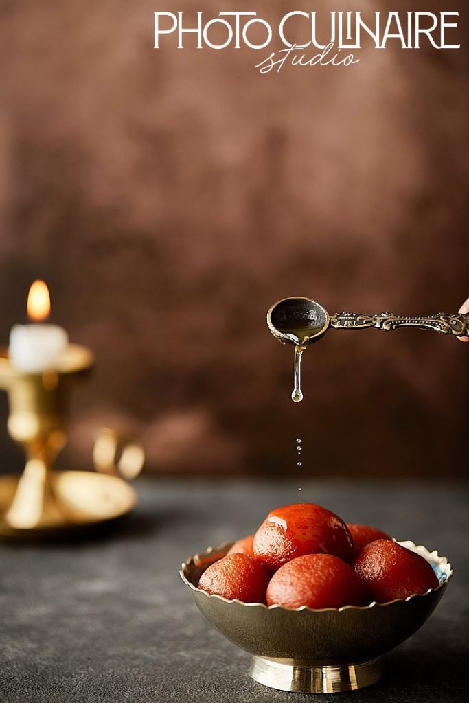 syrup drops frozen mid-air falling onto gulab jamun using fast shutter speed in food photography 