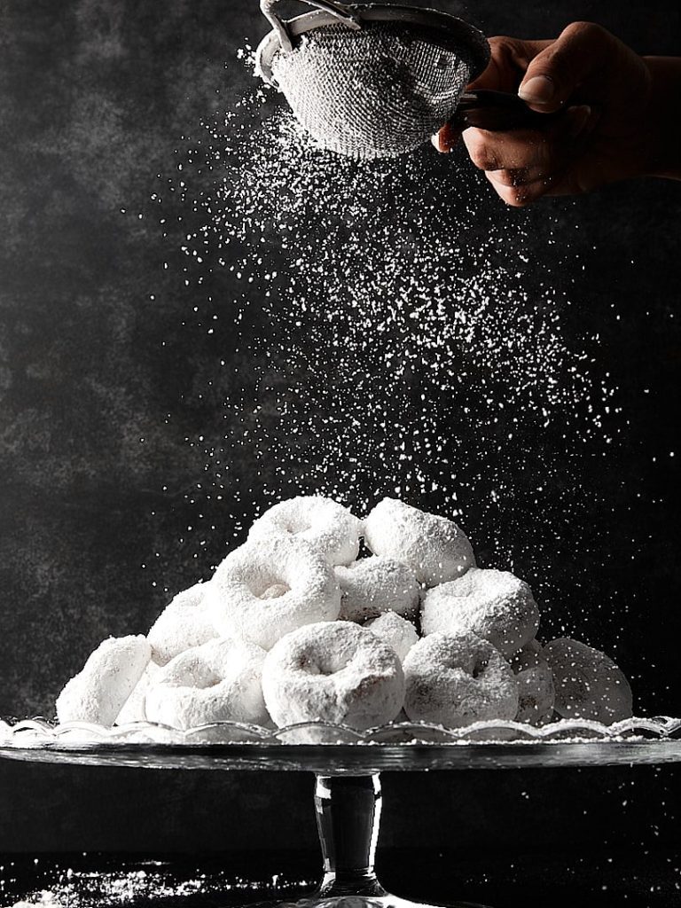 side lighting in food photography example with powdered sugar donuts and falling sugar